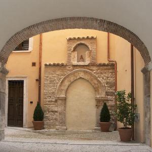 une arche devant un bâtiment avec deux plantes dans l'établissement B&B Residenza San Giorgio, à LʼAquila