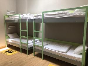 a room with two bunk beds with white sheets at Міні-готель "ЕКО" in Kamianets-Podilskyi