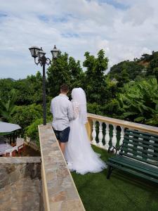 une mariée et un marié debout sur un pont dans l'établissement Hibiscus House Seychelles Self Catering, à Victoria