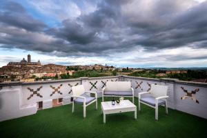 a patio with chairs and a table on a balcony at Villa Elda Boutique Hotel in Siena