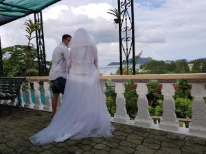 a bride and groom standing on a balcony at Hibiscus House Seychelles Self Catering in Victoria