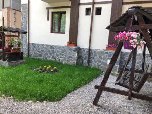 a garden with flowers on a swing in front of a house at Chez Marcel Sinaia in Sinaia