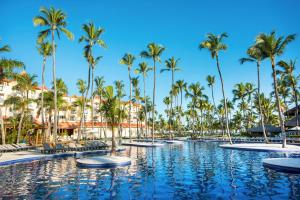 a pool at the resort with palm trees at Occidental Caribe - All Inclusive in Punta Cana