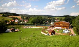 a green field with a house and a river at Sport-hotel Šibeniční vrch in Mnichovice