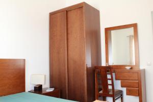 a bedroom with a bed and a dresser and a mirror at Apartamento Sto Estevão in Zambujeira do Mar