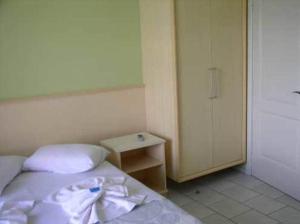 a bedroom with a bed and a dresser at Hotel Pousada Mineirinho in Balneário Praia do Leste