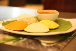 a plate of cookies and a bowl of dipping sauce at Pai Viceroy in Tirupati