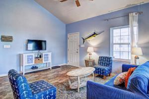 a living room with blue furniture and a tv at Breezy by the Beach in Corpus Christi