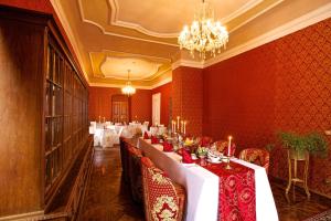 a dining room with a long table with red walls at Zámek Potštejn in Potštejn