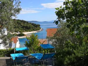 een groep blauwe stoelen op een balkon met uitzicht op de oceaan bij Luxury apartment with own terrace and sea view in Trogir