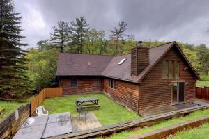 una pequeña casa de madera con mesa de picnic y banco en Gravelly Run Lodge, en McHenry