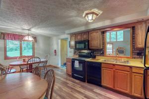 a kitchen with wooden cabinets and a table and a dining room at Gravelly Run Lodge in McHenry