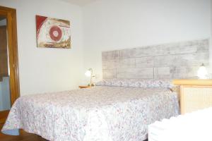 een slaapkamer met een bed met een sprei erop bij Apartmento AZKOITI in Ochagavía