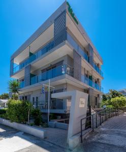 wysoki budynek z niebieskimi balkonami na ulicy w obiekcie 7Palms w mieście Rodos