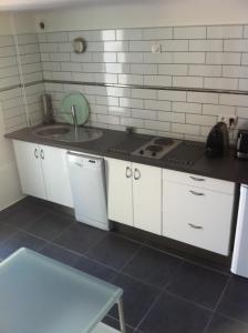 a kitchen with white cabinets and a sink and a counter at Gîte Polema in Marseille
