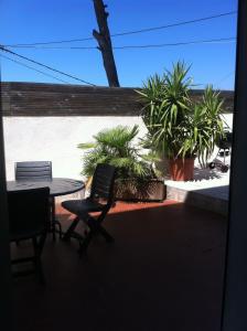 eine Terrasse mit einem Tisch, Stühlen und Pflanzen in der Unterkunft Gîte Polema in Marseille