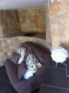 a couch in a stone wall with pillows on it at Gîte Polema in Marseille