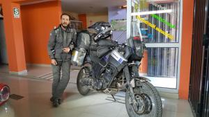 a man standing next to a motorcycle in a store at Hostal Los Pinos in Huancayo