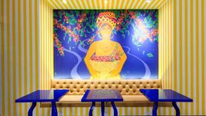 a mural of a woman sitting on a bench with two tables at Pop Art Hotel Las Colinas Manizales in Manizales +54 photos