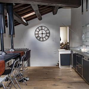 a large kitchen with a clock on the wall at B&B Residenza San Giorgio in LʼAquila