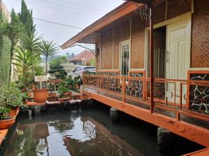 a house with a pond in front of it at Villa Daffa Ciwidey in Ciwidey