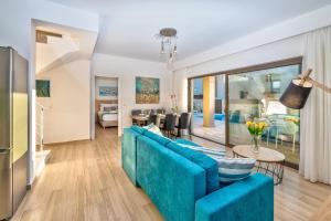 a living room with a blue couch and a dining room at Platanias Villa Mirsini in Plataniás