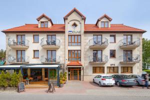 un grande edificio con macchine parcheggiate di fronte di Villa Dune a Sarbinowo