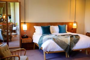 a hotel room with a bed, chair, and nightstand at Bingham Riverhouse in Richmond upon Thames