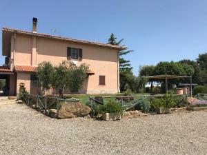 un giardino di fronte a una casa con piante di Agriturismo San francesco a Orbetello Altre 11 foto