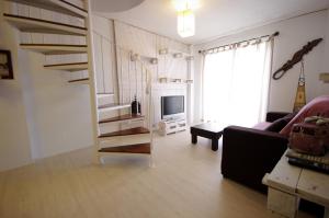 sala de estar con escalera de caracol y TV en Livingtarifa Apartamento Nano, en Tarifa