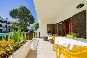 een patio met een tafel en stoelen en een zwembad bij Apartamento Moura Mar in Vilamoura