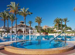 a pool at a resort with palm trees at Ona Mar Menor Golf & Spa in Torre-Pacheco