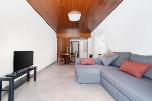 a living room with a couch and a flat screen tv at Apartamento Moura Mar in Vilamoura