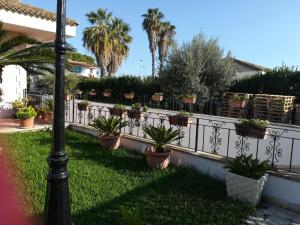 a white fence with potted plants on it at A casa di Franco in Marina di Ragusa
