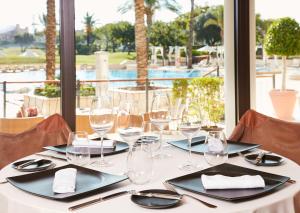 
a man sitting at a table with plates of food at Caleia Mar Menor Golf & Spa Resort in Torre-Pacheco
