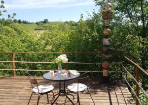 un tavolo e sedie su una terrazza in legno di le cri de la yourte a Saint-Urcisse