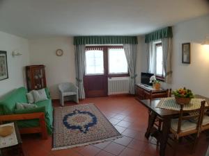 a living room with a green couch and a table at CASA BRENZ in Madonna di Campiglio