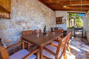 - une table en bois dans une chambre dotée d'un mur en pierre dans l'établissement Apartments Davor, à Mošćenička Draga