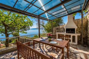 an outdoor patio with a table and a fireplace at Apartments Davor in Mošćenička Draga