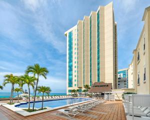 un hotel con piscina y palmeras en Catalonia Santo Domingo, en Santo Domingo