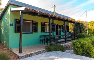 a green and yellow house with a table outside at Kuća za odmor- Simona in Punta Križa