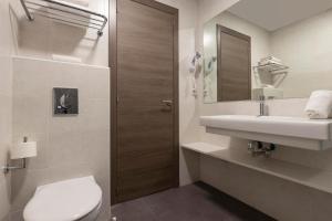 łazienka z toaletą, umywalką i lustrem w obiekcie Hotel Palia La Roca w mieście Benalmádena