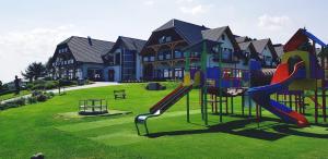 a playground in front of a house with a slide at Wichrowe Wzgórze Chmielno in Chmielno