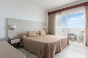 sypialnia z łóżkiem i widokiem na ocean w obiekcie Hotel Palia La Roca w mieście Benalmádena