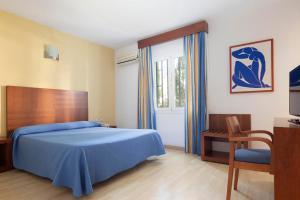 Un dormitorio con una cama azul y una ventana en Hotel Palia La Roca, en Benalmádena