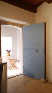 a blue door in a room with a window at BORGO PETELIA, Casa Chiarotti, Antica casa con scala esterna in Strongoli