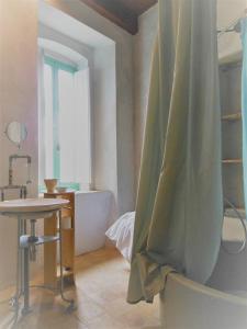 a bathroom with a green shower curtain and a table at BORGO PETELIA, Casa Chiarotti, Antica casa con scala esterna in Strongoli