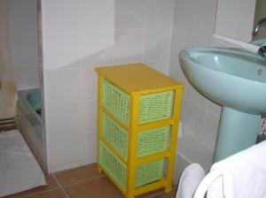 a bathroom with a yellow and green cabinet next to a sink at Le Mas des Baux in Bédoin