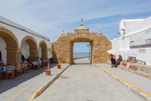 a building with an archway with tables and chairs at BARQUILLAS de la Caleta Home by Cadiz4Rentals in Cádiz
