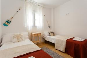 a white room with two beds and a window at BARQUILLAS de la Caleta Home by Cadiz4Rentals in Cádiz